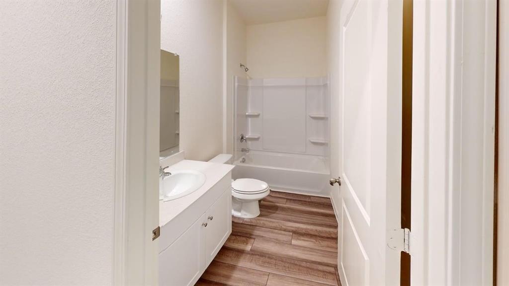 4529 Winecup Road Melissa, TX 75454 - Photo 23 of 29 Bathroom featuring a white vanity with an integrated sink, polished chrome faucet, and a large wall-mounted mirror