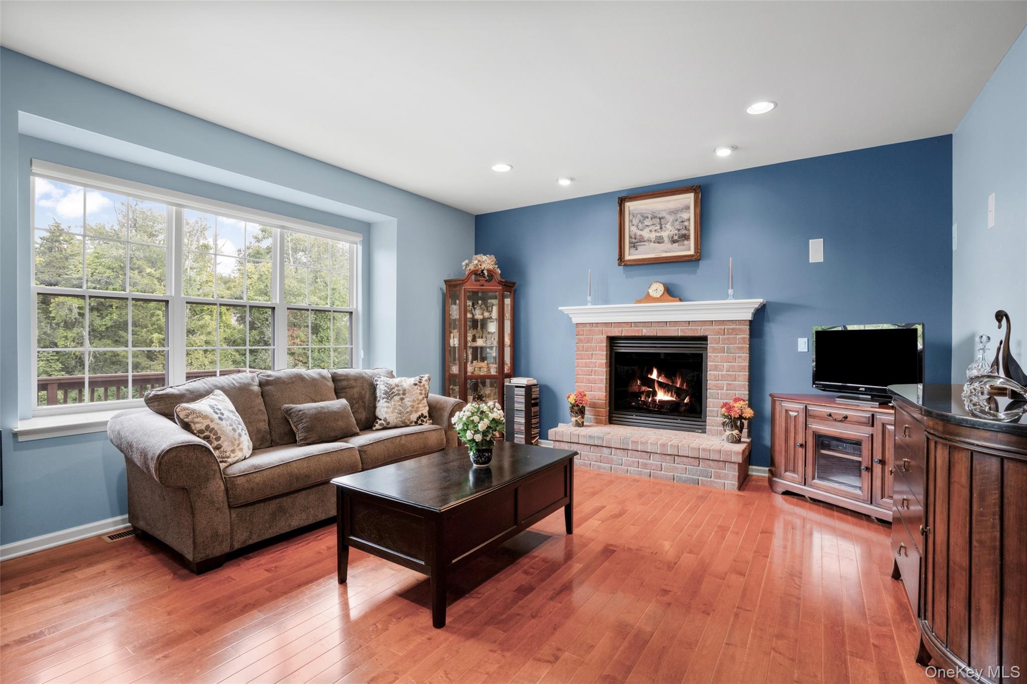 653 Creekside Lane Fishkill, NY 12524 - Photo 12 of 36 a living room with furniture a flat screen tv and a fireplace