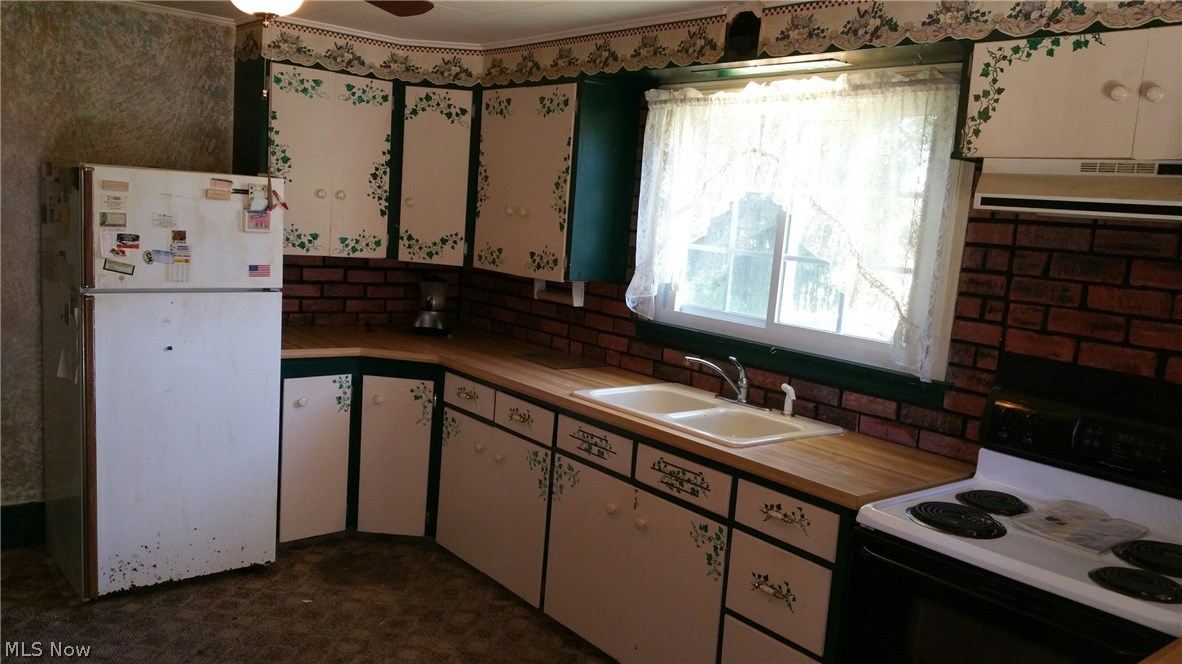 6308 Wayland Road Ravenna, OH 44266 - Photo 6 of 22 First view of kitchen with hand painted cabinets, ref/freezer, electric range.