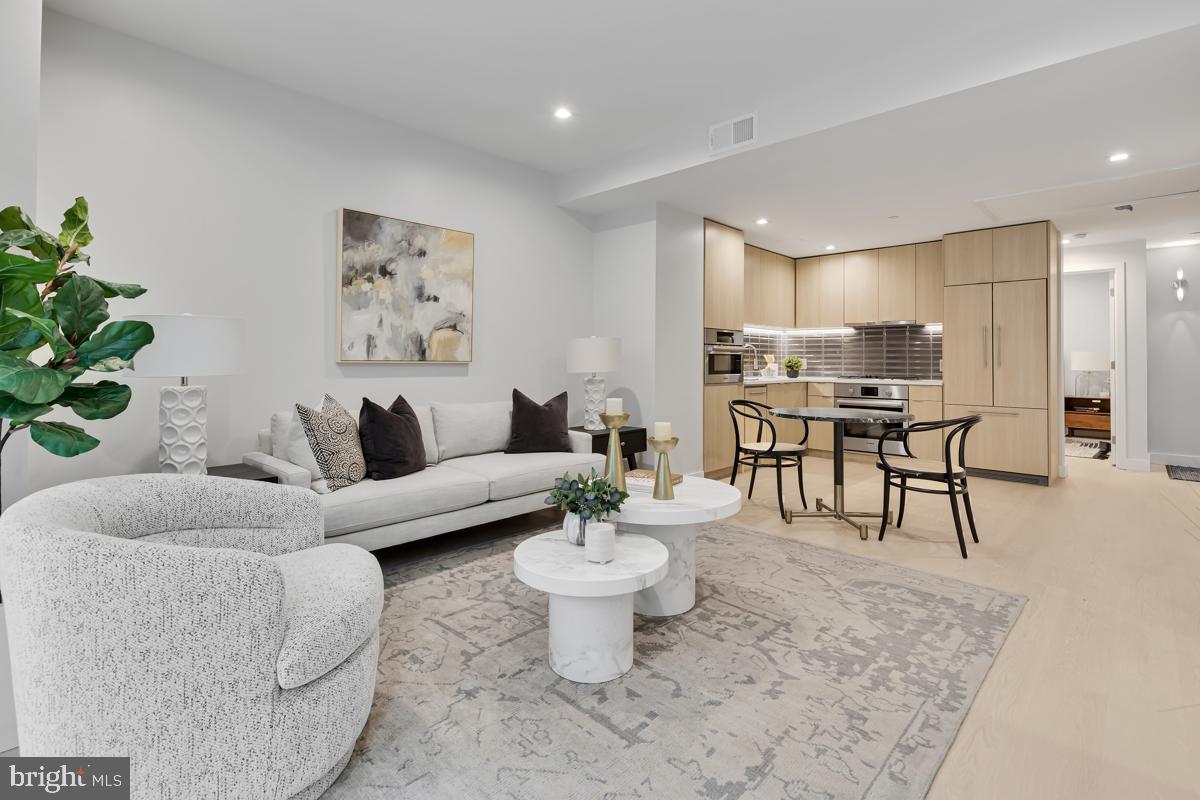 a living room with furniture and a dining table with potted plant