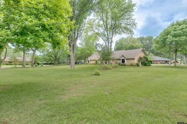 a view of a house with garden and trees