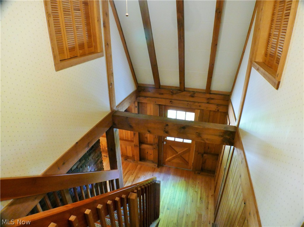 17340 Huntley Road Huntsburg, OH 44046 - Photo 14 of 24 Stairway with vaulted ceiling with beams and wood-type flooring