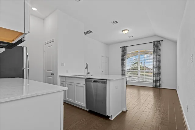 a kitchen with kitchen island a sink stainless steel appliances and cabinets