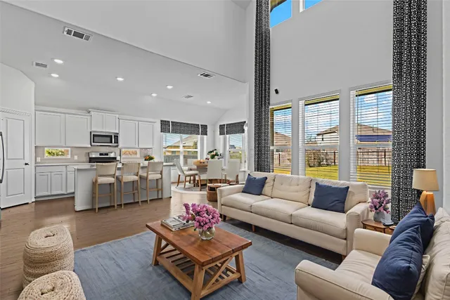 a living room with furniture kitchen and a large window
