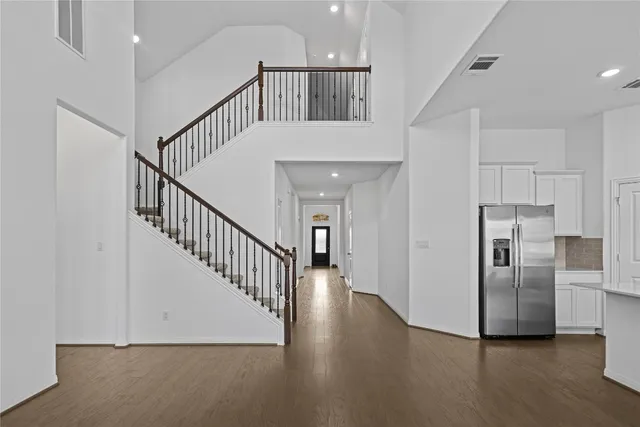 a view of a hallway with wooden floor and staircase