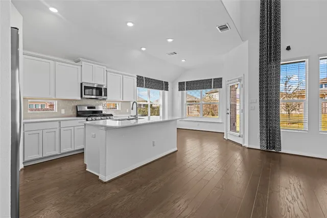 a kitchen with counter top space cabinets and appliances