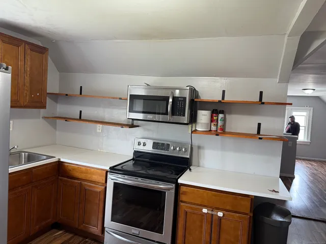 a kitchen with stainless steel appliances a stove microwave and sink