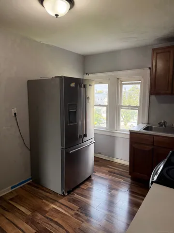 a kitchen with granite countertop a refrigerator and a stove top oven