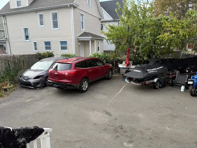a car parked in front of a white house