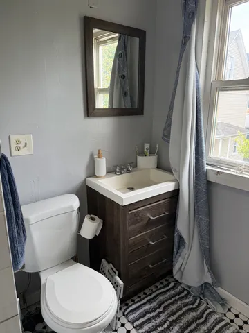 a bathroom with a toilet sink and mirror