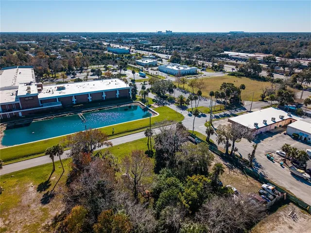an aerial view of a house with a swimming pool lake and mountain view