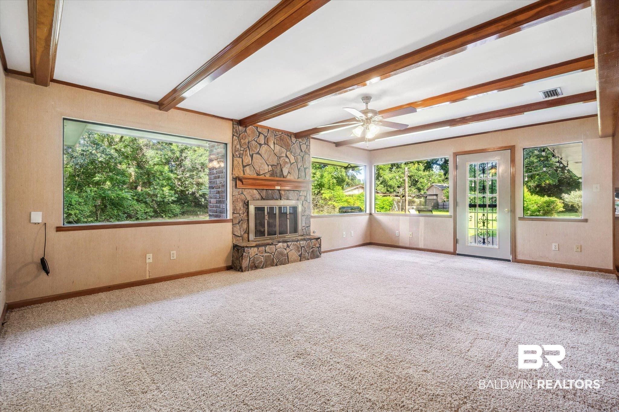1252 Helm Circle Mobile, AL 36693 - Photo 9 of 18 Unfurnished living room featuring beam ceiling, carpet flooring, a fireplace, and ceiling fan