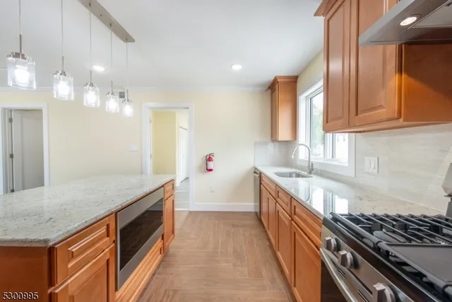 a large kitchen with stainless steel appliances granite countertop a stove and a sink