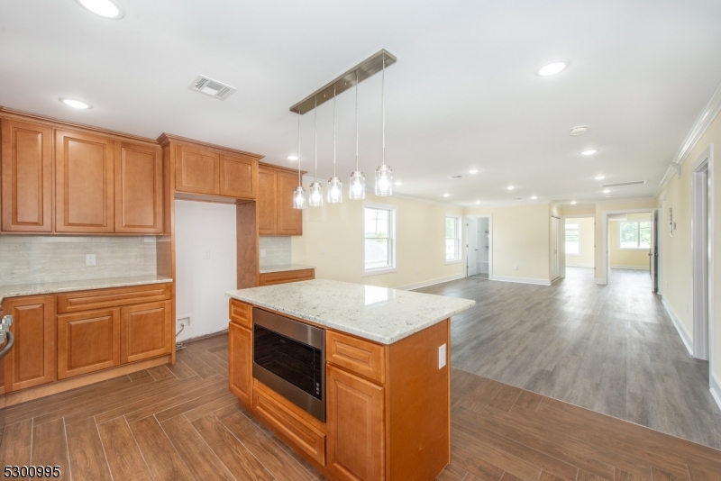 67 Harrison Street Nutley, NJ 07110 - Photo 5 of 20 a kitchen with stainless steel appliances granite countertop a stove a sink dishwasher and a refrigerator with wooden floor