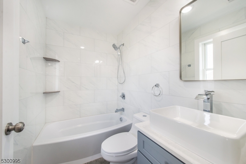 67 Harrison Street Nutley, NJ 07110 - Photo 8 of 20 a bathroom with a sink a toilet and a bathtub