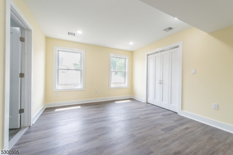 67 Harrison Street Nutley, NJ 07110 - Photo 10 of 20 an empty room with wooden floor and windows