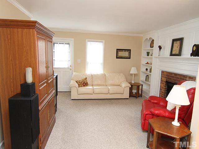 6800 Daltrey Court Raleigh, NC 27613 - Photo 4 of 12 a living room with furniture a flat screen tv and a fireplace