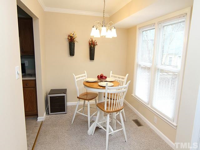 6800 Daltrey Court Raleigh, NC 27613 - Photo 5 of 12 a dining room with furniture a chandelier and window