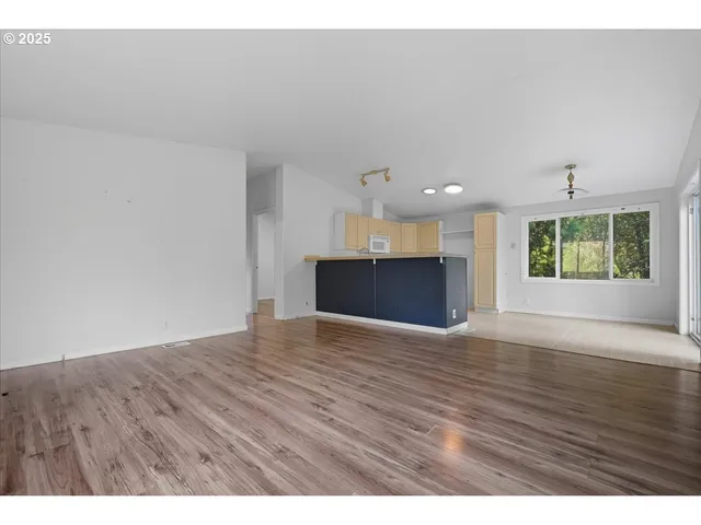 a view of empty room with wooden floor and windows