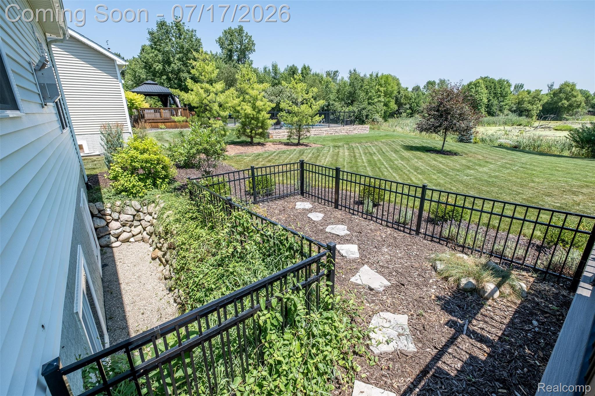 12349 Sugar Maple Drive Fenton, MI 48430 - Photo 53 of 67 Expansive backyard with a manicured lawn, bordered by a black metal fence