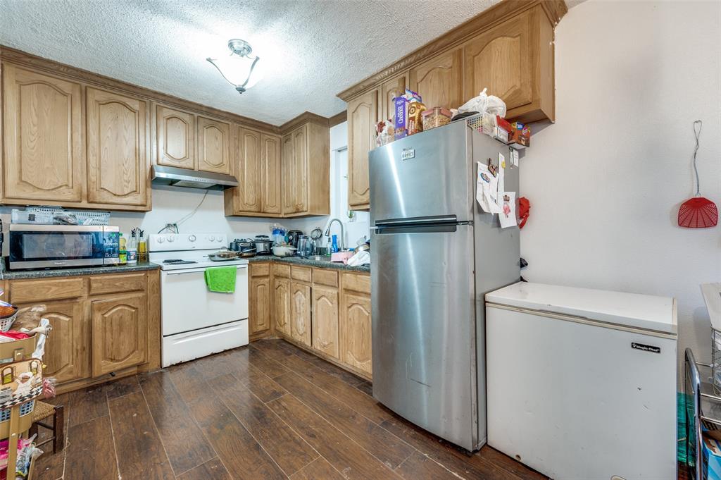 419 North Frances Street Dallas, TX 75211 - Photo 21 of 25 a kitchen with refrigerator a sink and cabinets