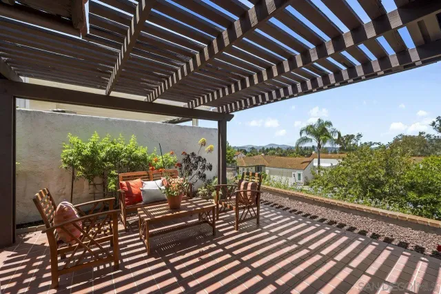 a view of a balcony with chairs and a potted plant