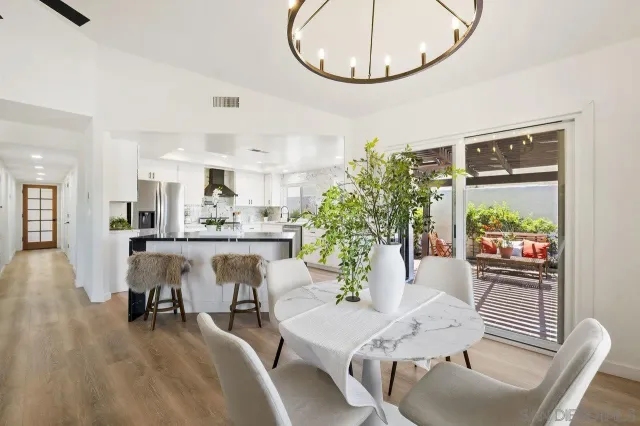 a living room with furniture a table and kitchen chandelier