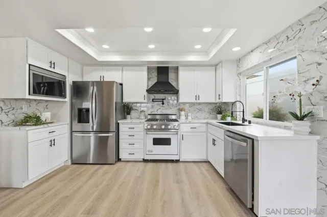 a kitchen with stainless steel appliances a refrigerator sink and microwave