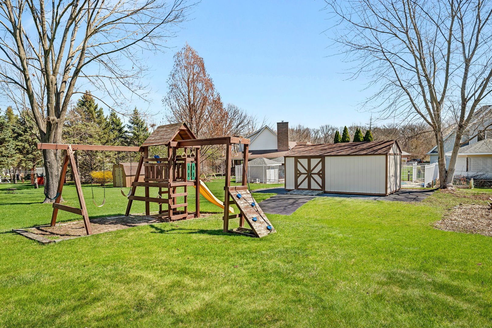 108 Deerpath Drive Minooka, IL 60447 - Photo 37 of 45 a view of a backyard with a slide trees and wooden fence