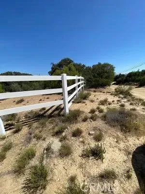 a view of a yard with wooden fence