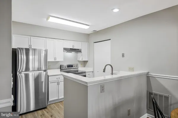 a kitchen with stainless steel appliances granite countertop a refrigerator sink stove and microwave