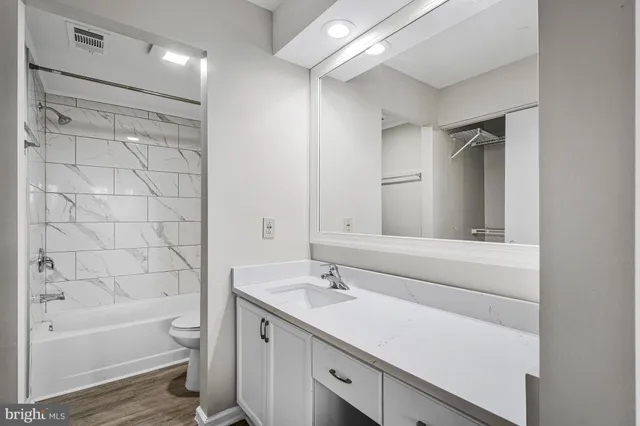 a bathroom with a bathtub shower sink vanity and a toilet