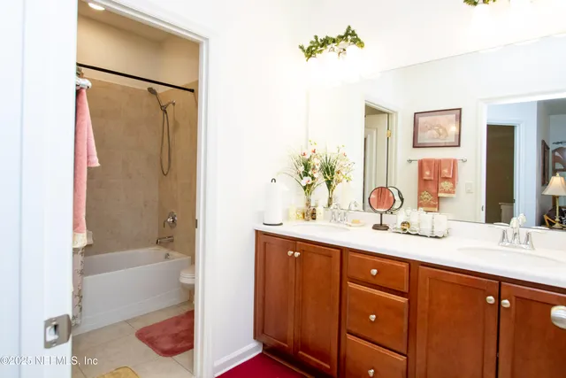 a bathroom with a tub sink and mirror