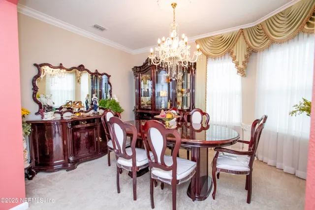 a view of a dining room with furniture and chandelier