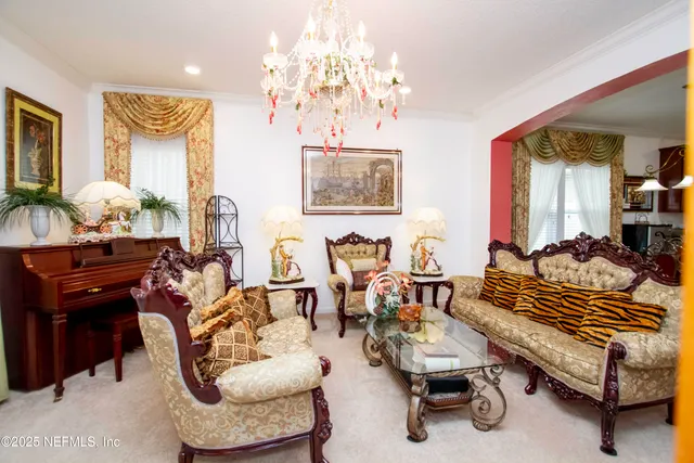 a living room with furniture a piano and a chandelier
