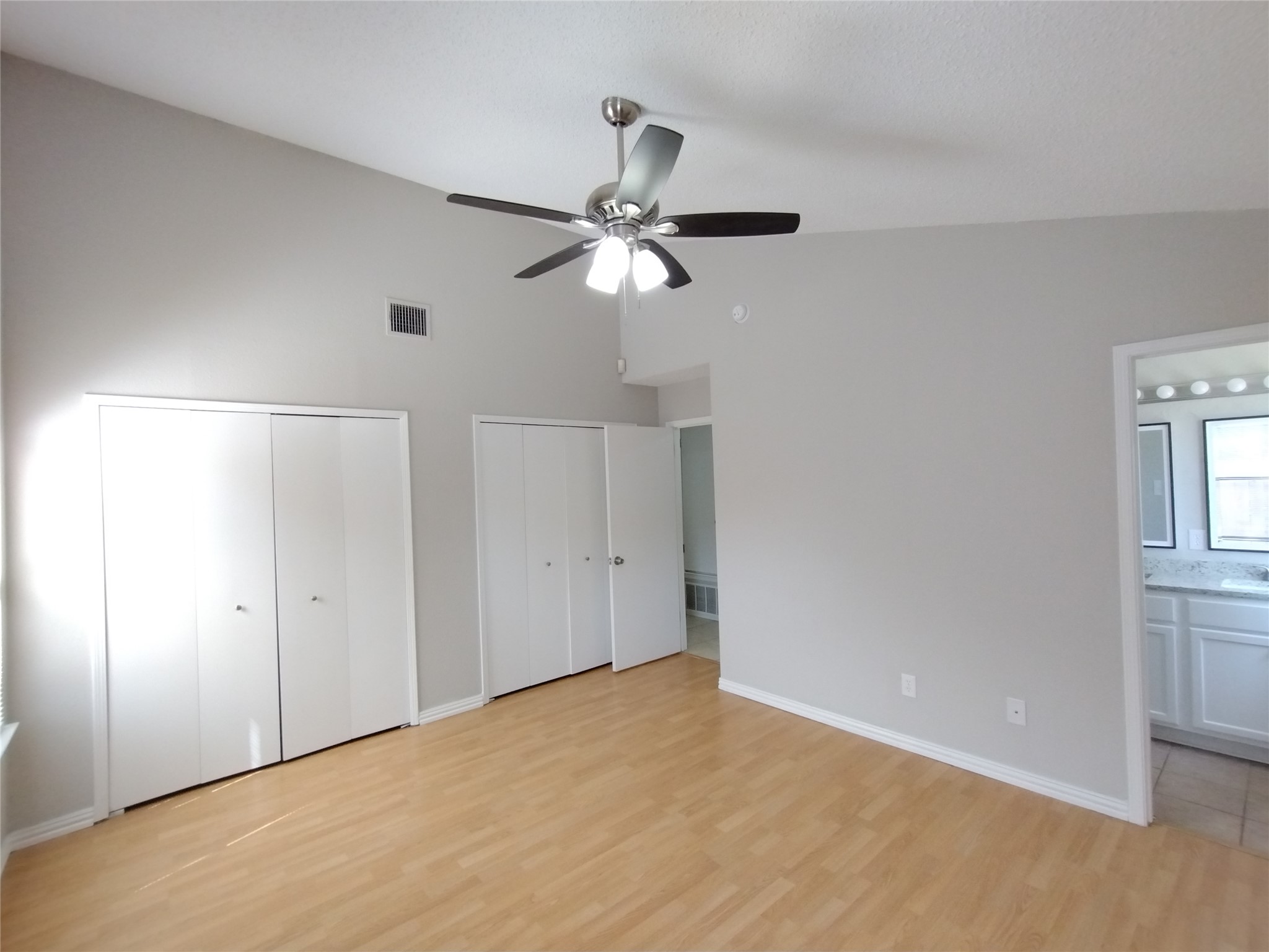 1813 Laurel Path Round Rock, TX 78664 - Photo 25 of 35 A vaulted ceiling and warm wood flooring define this comfortable primary bedroom, complete with ample closet space.