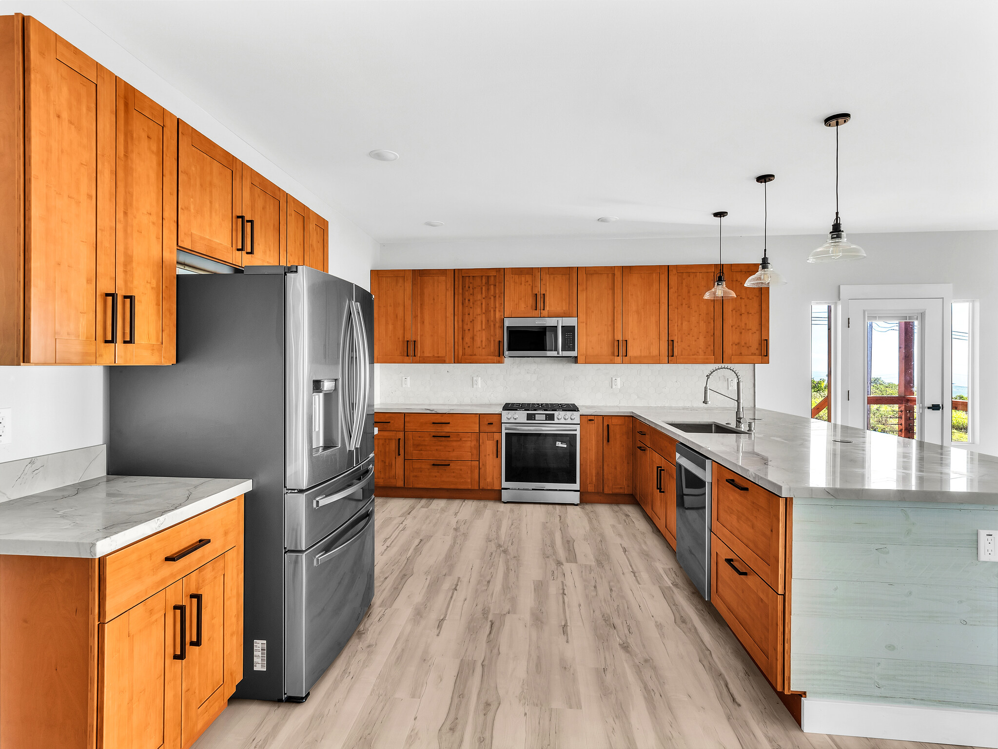 94-1549 Ha'Eha'e Street Naalehu, HI 96772 - Photo 11 of 30 a large kitchen with stainless steel appliances granite countertop a stove a sink dishwasher and a refrigerator