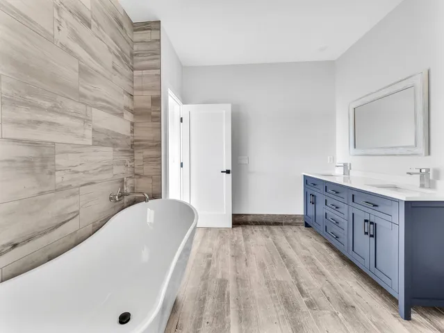 a bathroom with a granite countertop bathtub sink vanity and mirror