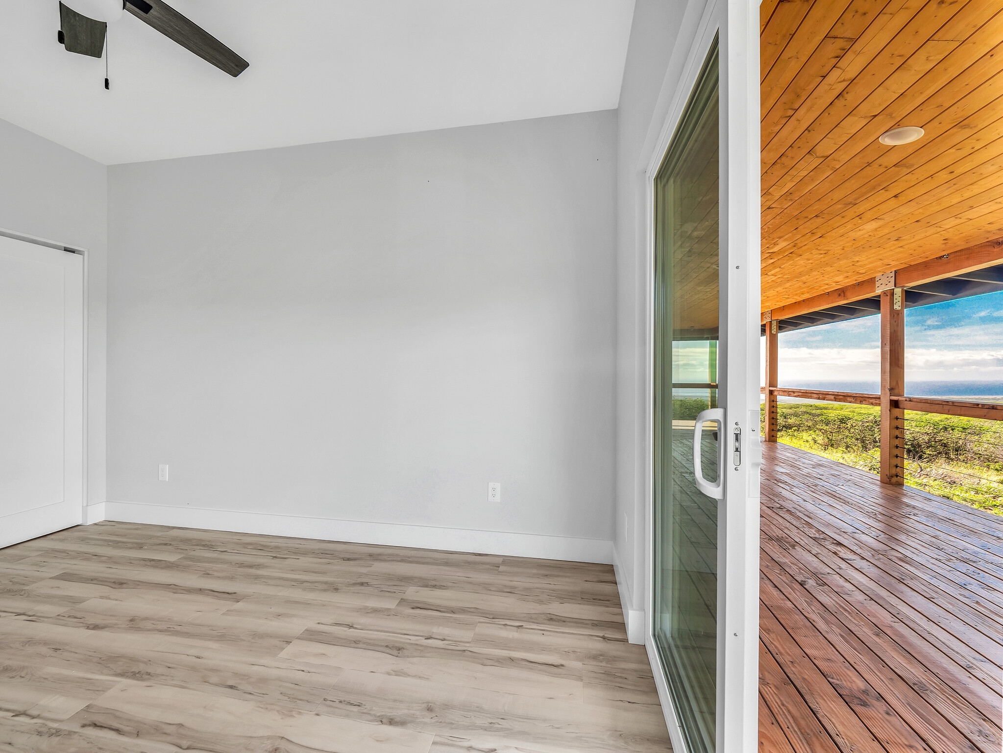 94-1549 Ha'Eha'e Street Naalehu, HI 96772 - Photo 20 of 30 an empty room with wooden floor and windows