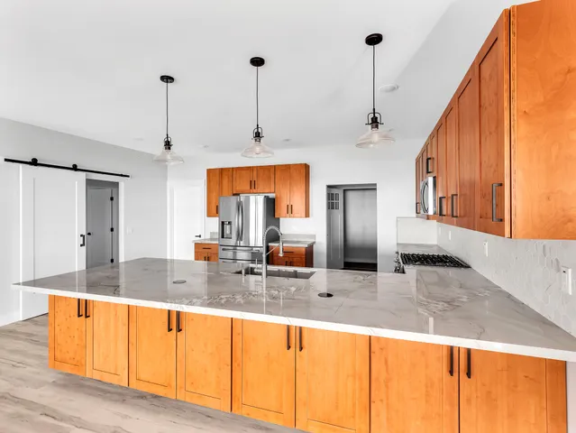 a kitchen with stainless steel appliances granite countertop a sink and a refrigerator
