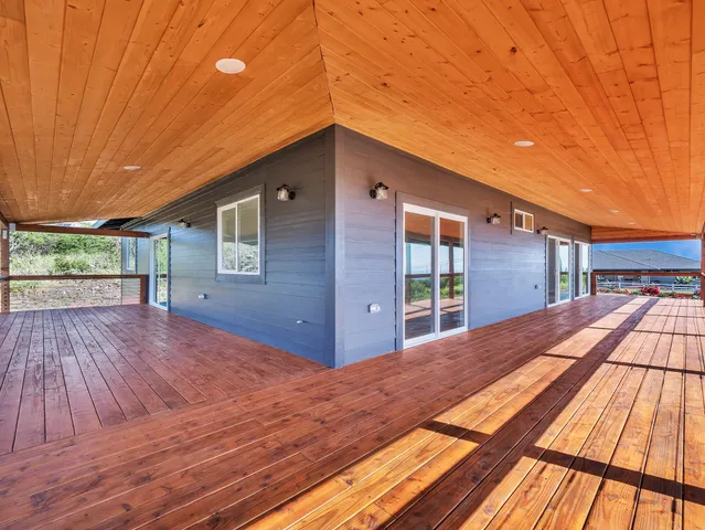 a view of backyard with a deck and wooden floor