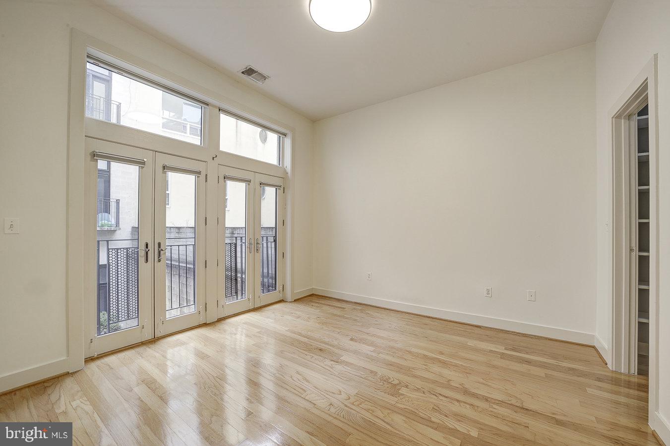2357 Champlain Street Northwest, Unit 201 Washington, DC 20009 - Photo 5 of 13 a view of an empty room with wooden floor and a window