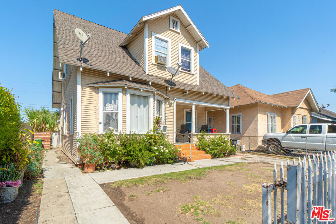 721 East 42nd Place Los Angeles, CA 90011 - Photo 2 of 8 a front view of a house with a garden