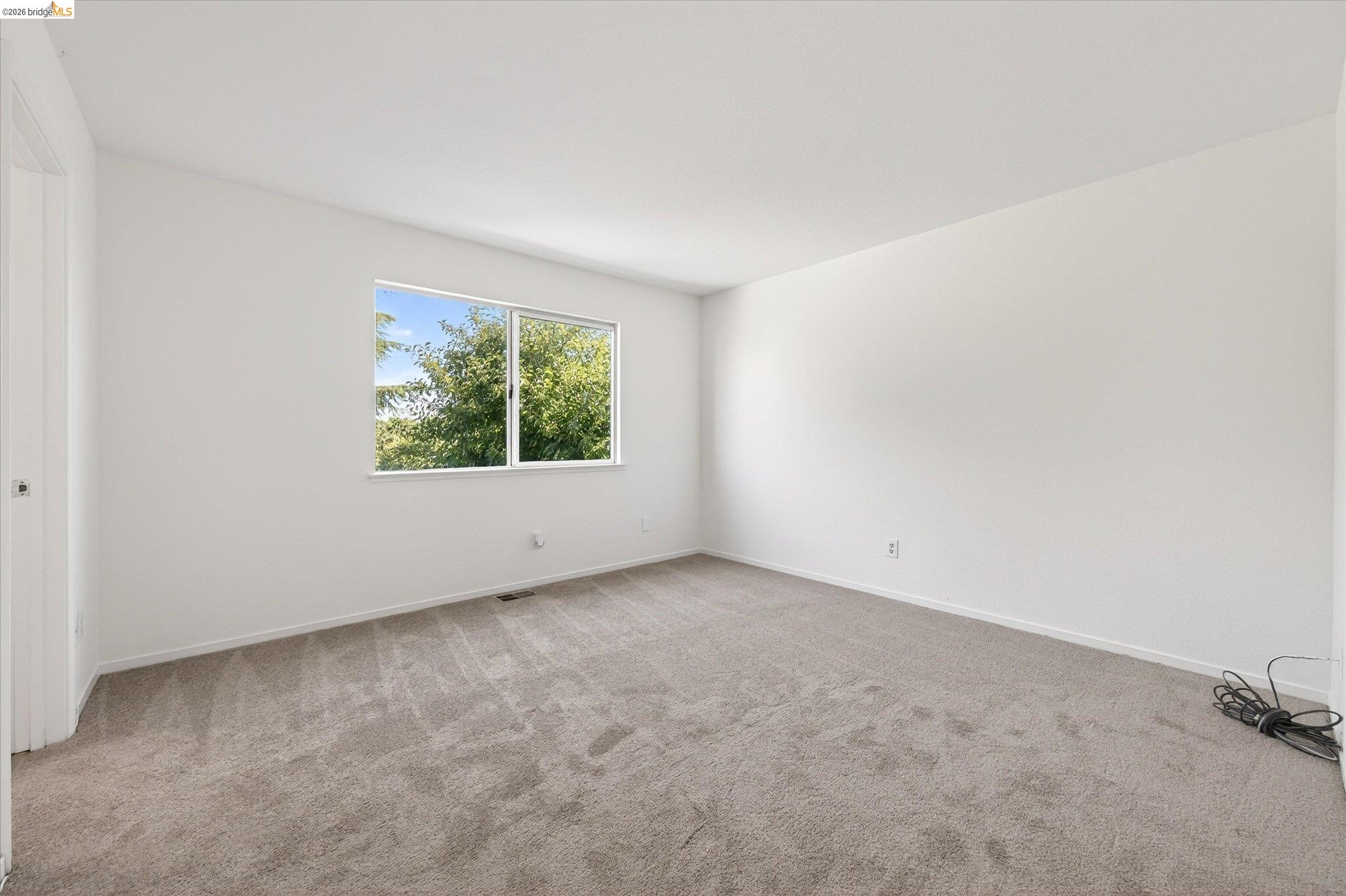 1120 Deerpark Road Oakley, CA 94561 - Photo 20 of 30 Spacious room featuring neutral carpeting, white walls, and a large window framing mature trees