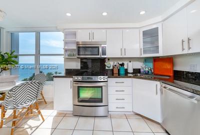 609 Ocean Drive, Unit 8G Key Biscayne, FL 33149 - Photo 11 of 44 a kitchen with stainless steel appliances granite countertop a stove a sink and a microwave