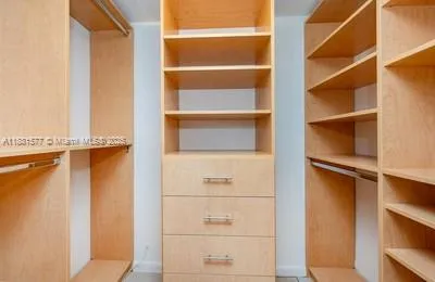 a view of walk in closet with empty racks