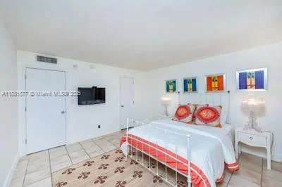 a bedroom with a bed and a flat screen tv