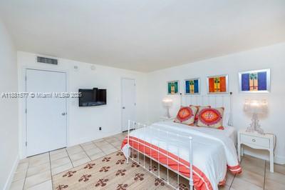 609 Ocean Drive, Unit 8G Key Biscayne, FL 33149 - Photo 23 of 44 a bedroom with a bed and a flat screen tv