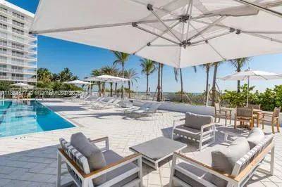 a view of a patio with a dining table and chairs under an umbrella