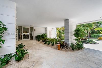 609 Ocean Drive, Unit 8G Key Biscayne, FL 33149 - Photo 33 of 44 a view of a house with potted plants and a bench